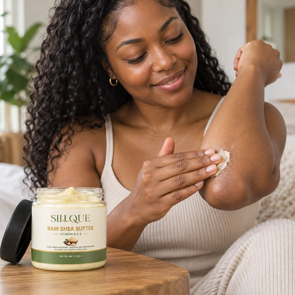 Black woman smoothing Sillque Raw Shea Butter onto her elbow